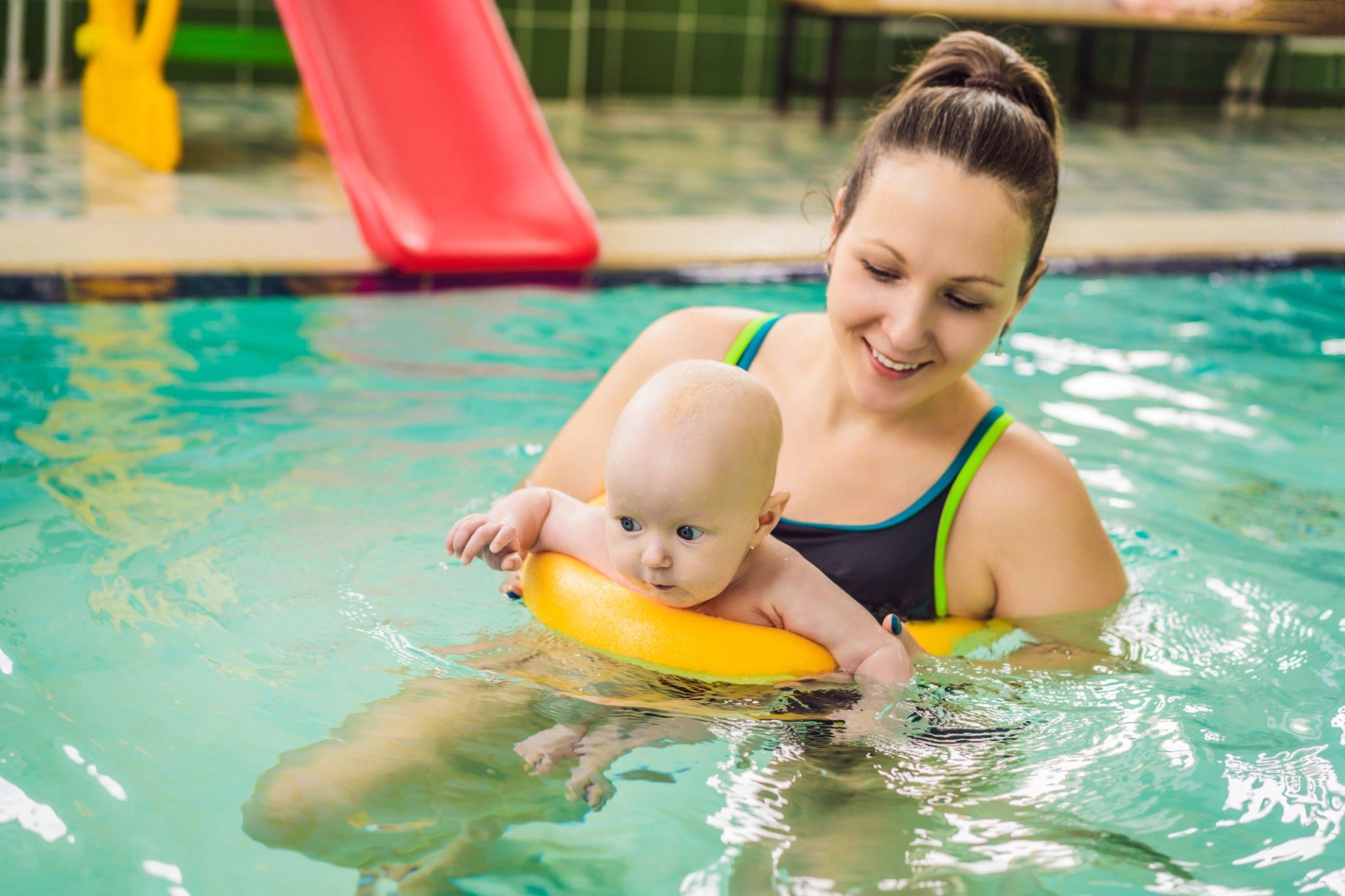 A baby is enjoying her swimming lessons with her coach at the pools of Hallandale