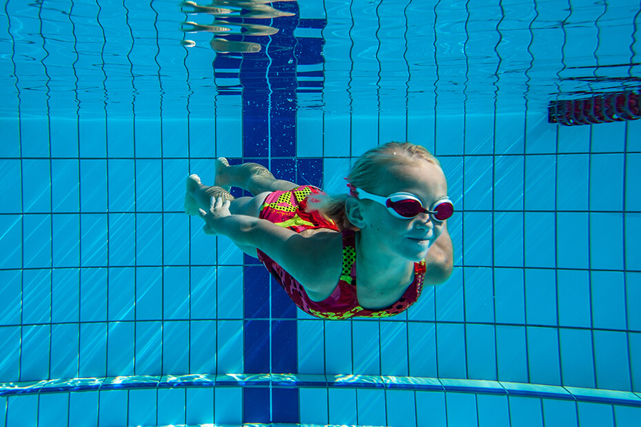 A child is enjoying under water swimming lessons at the pools of Miami Gardens