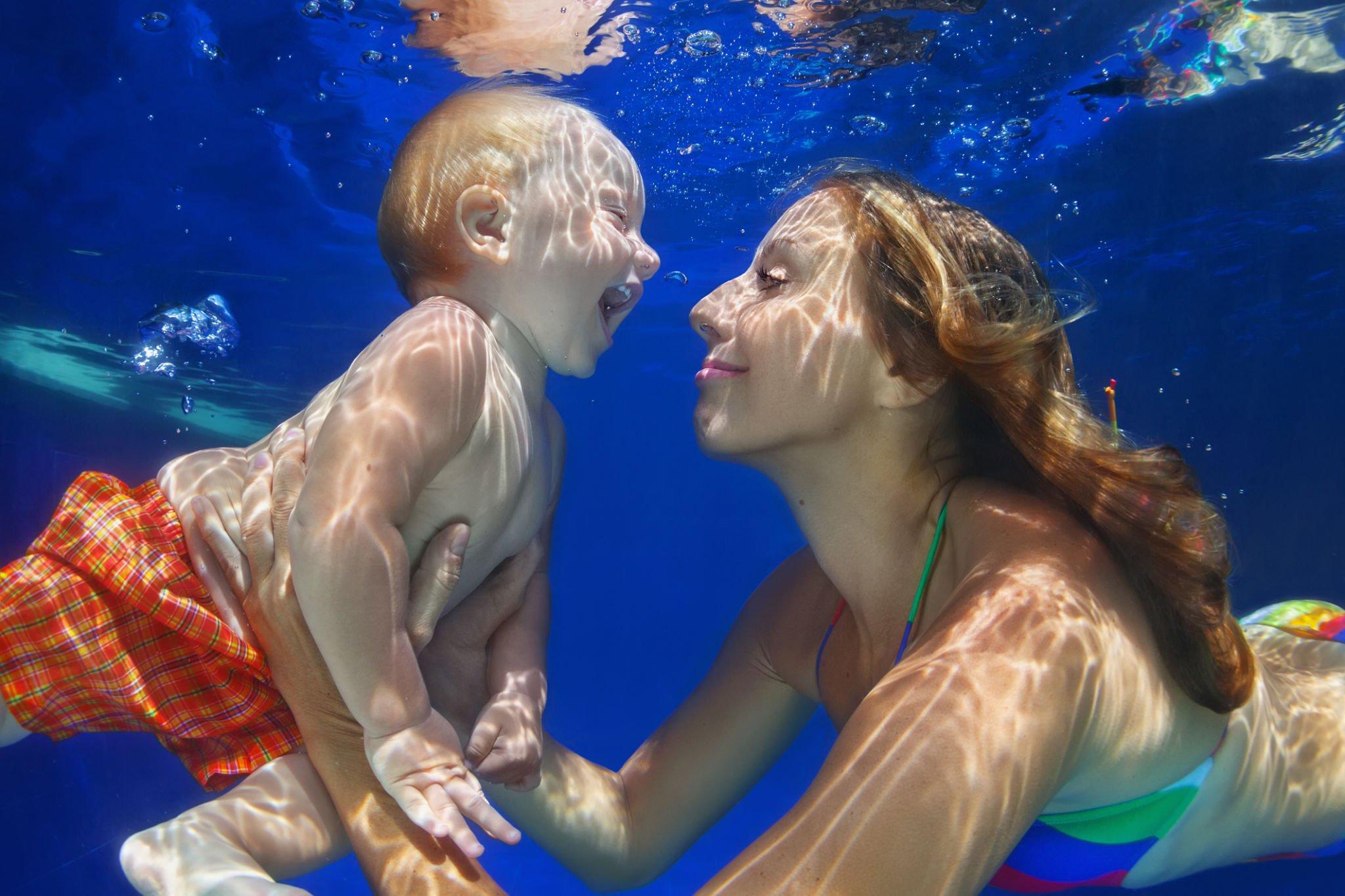 A baby having an under water swim experience with her lady Coach here at the pools of Sunny Isles Beach